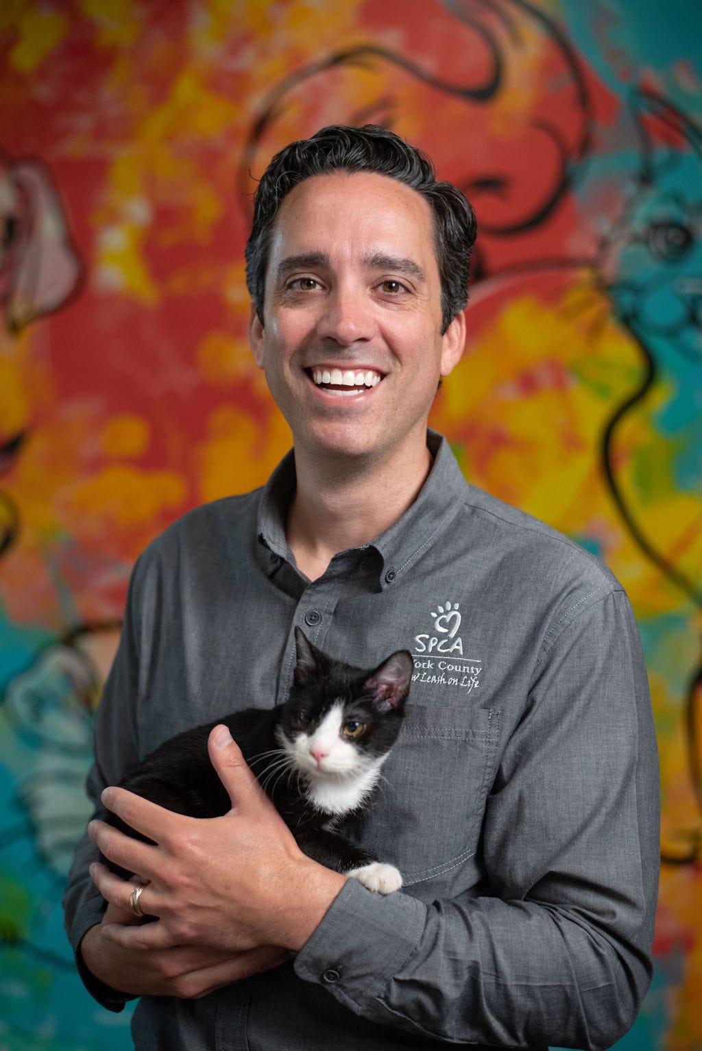 Person holding a black and white cat.